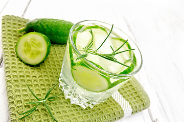 Image showing Lemonade with cucumber and rosemary in glassful on green napkin