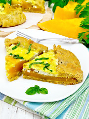 Image showing Pie of pumpkin and basil in plate on light board