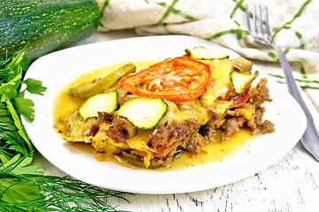 Image showing Casserole from minced meat and zucchini in plate on light board