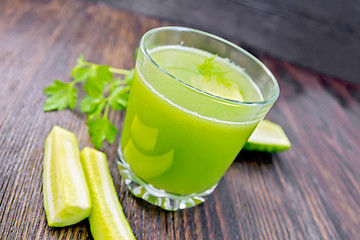 Image showing Juice cucumber in glassful with vegetables on dark board