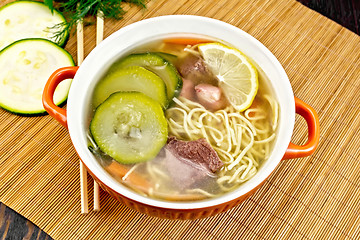 Image showing Soup with zucchini and noodles on bamboo napkin
