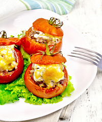 Image showing Tomatoes stuffed with meat on lettuce in plate on light board