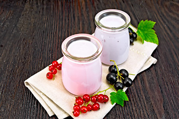 Image showing Milk cocktail with red and black currant on dark board