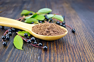 Image showing Flour bird cherry in spoon with berries on board