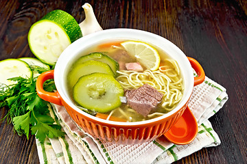 Image showing Soup with zucchini and noodles in bowl on kitchen towel