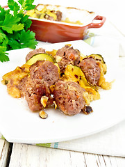 Image showing Meatballs with zucchini and nuts in plate on towel