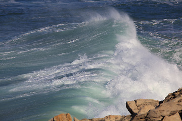 Image showing Marine wave breaks against offshore stone