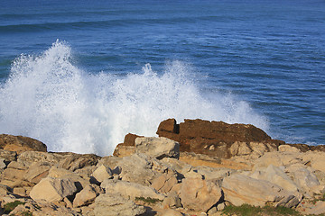 Image showing Marine wave breaks against offshore stone