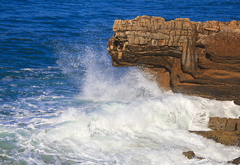 Image showing Marine wave breaks against offshore stone