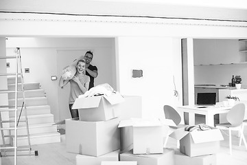 Image showing couple carrying a carpet moving in to new home