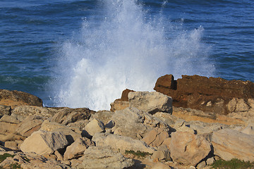 Image showing Marine wave breaks against offshore stone