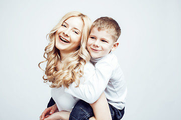 Image showing young modern blond curly mother with cute son together happy smiling family posing cheerful on white background, lifestyle people concept, sister and brother friends