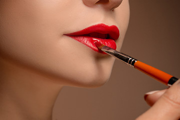 Image showing Beautiful female lips with make-up and brush