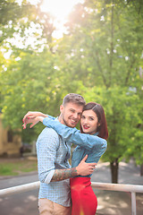 Image showing Happy young couple at park standing and laughing on the bright sunny day