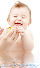 Image showing laughing baby boy in water playing with rubber duck