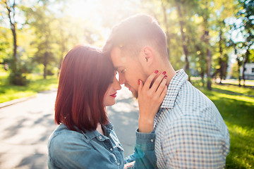 Image showing Happy young couple at park standing and laughing on the bright sunny day