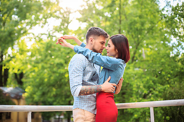 Image showing Happy young couple at park standing and laughing on the bright sunny day