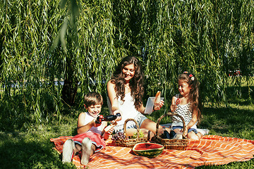 Image showing cute happy family on picnic laying on green grass mother and kid