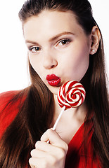 Image showing young pretty brunette girl with red candy posing on white background isolated