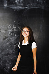 Image showing portrait of happy cute student in classroom at blackboard back t