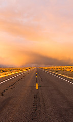 Image showing Storm Brews over Two Lane Highway At Sunset