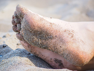 Image showing Feet of one unrecognizable caucasian person resting in sand, wit