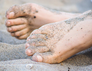 Image showing Feet of one unrecognizable caucasian person resting in sand, wit