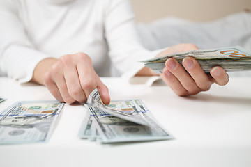 Image showing Close up of woman with calculator counting money