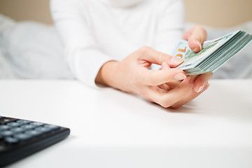 Image showing business, finance, saving, banking and people concept - close up of woman hands counting us dollar money