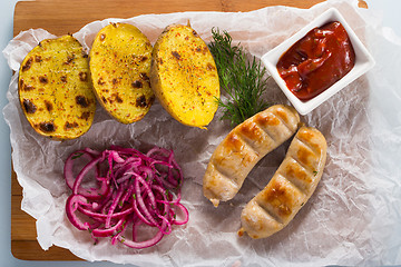 Image showing macro meat kupaty with fries and greens on white plate