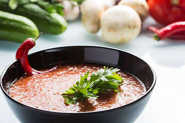 Image showing tomato soup in a black plate. 