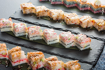 Image showing set of sushi on a slate square plate. 