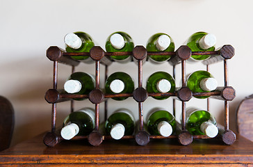 Image showing white wine bottles stored on wooden rack