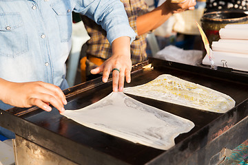 Image showing woman cooking roti pancakes at street market