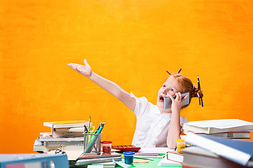 Image showing The Redhead teen girl with lot of books at home. Studio shot