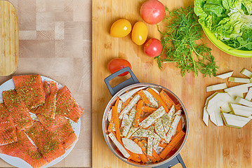 Image showing Salmon fish preparation for cooking, chopped vegetables, salt and knife