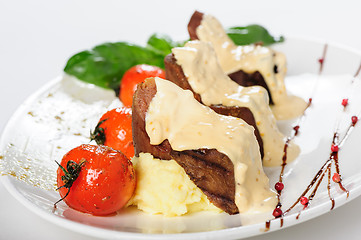 Image showing Baked mutton meat with creamy sauce, mashed potato and cherry tomatoes