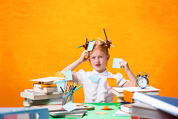 Image showing The Redhead teen girl with lot of books at home. Studio shot