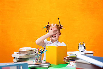 Image showing The Redhead teen girl with lot of books at home. Studio shot