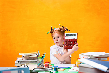 Image showing The Redhead teen girl with lot of books at home. Studio shot