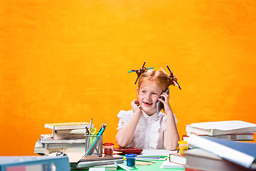 Image showing The Redhead teen girl with lot of books at home. Studio shot