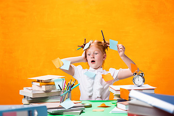 Image showing The Redhead teen girl with lot of books at home. Studio shot