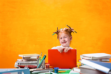 Image showing The Redhead teen girl with lot of books at home. Studio shot