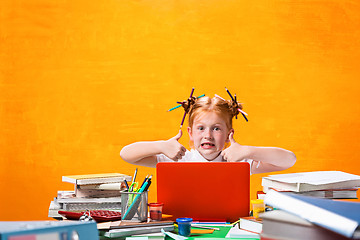 Image showing The Redhead teen girl with lot of books at home. Studio shot