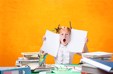 Image showing The Redhead teen girl with lot of books at home. Studio shot