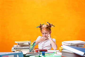 Image showing The Redhead teen girl with lot of books at home. Studio shot