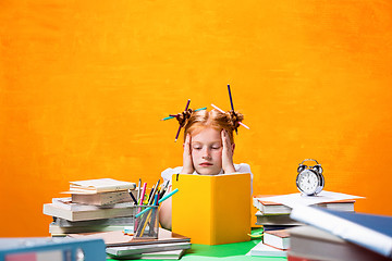 Image showing The Redhead teen girl with lot of books at home. Studio shot