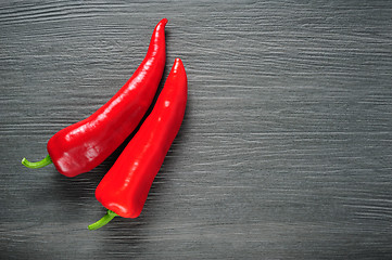 Image showing Two red Kapia peppers on a dark shale stone background