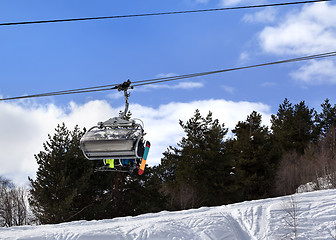 Image showing Skiers and snowboarders on chair-lift in winter mountain