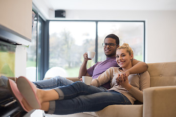 Image showing Young multiethnic couple  in front of fireplace